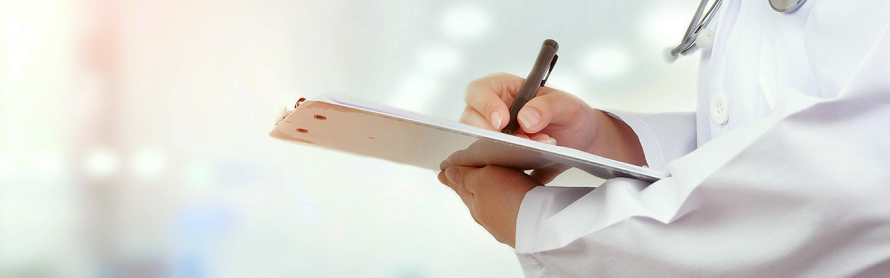 Doctor filling out a form on a clipboard